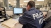 Un oficial de ICE monitorea una operación de la agencia. 