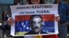 Una mujer sostiene un cartel contra nicolás Maduro durante una marcha frente a la embajada de Venezuela en Ciudad Guatemala.