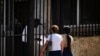 Dos personas esperan su turno en el exterior de la embajada de Estados Unidos el día después de la reapertura de los servicios consulares, en La Habana. (Ramón Espinosa/AP)