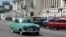 Un auto clásico pasa frente a la sede del capitolio cubano.