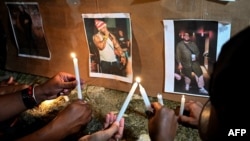 Cubans light candles next to pictures of late reggaeton singer Jose Manuel Carbajal 'El Taiger' as they pay tribute in Havana on October 10, 2024.