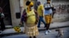 Una mujer con girasoles y una máscar para protegerse del coronavirus en una calle de La Habana. (AP/Ramon Espinosa)