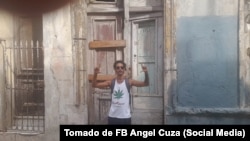 Ángel Cuza hace la señal de "Libertad" con sus manos frente a la casa de Luis Manuel Otero Alcántara.