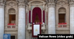 El nuevo Papa flanqueado por los cardenales, en el balcón de la Basílica de San Pedro, se dirige a la multitud congregada en la plaza del mismo nombre.
