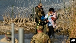 Funcionarios detienen a migrantes en la frontera entre Texas y México, el miércoles 3 de enero de 2024, en Eagle Pass, Texas. (AP Foto/Eric Gay)