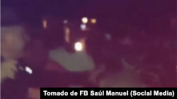 Un oficial del Ministerio del Interior alumbra con una linterna a los manifestantes, durante la protesta del 23 de mayo de 2025 en Bayamo.